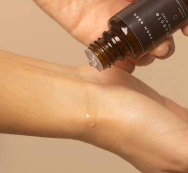 A person's hands are shown dispensing clear drops of